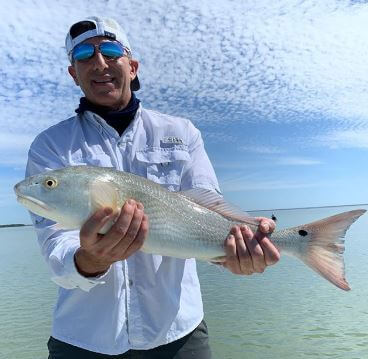 Edward Butera showing off his catch, a redfish.